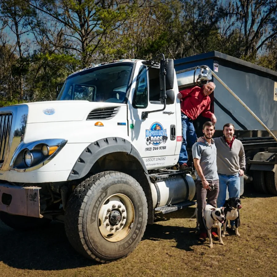 The Dumpster Rental Dogs family team with their truck and dogs