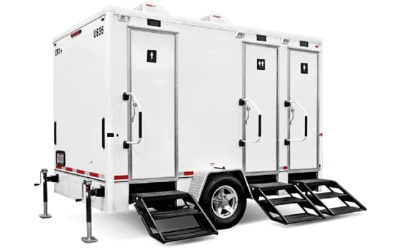 Luxury white mobile restroom trailer with three stalls, each with a door and small set of stairs leading up to it.